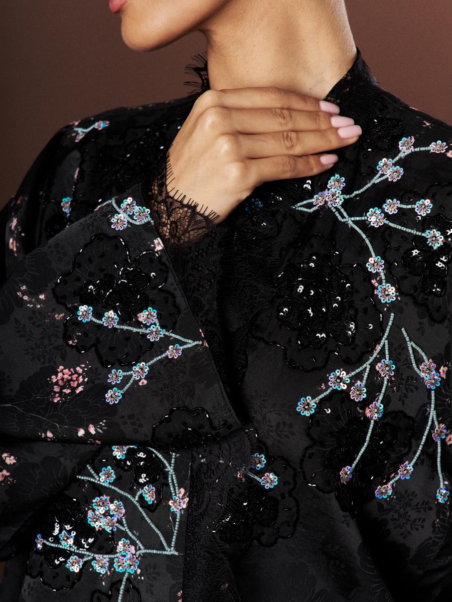 Close-up of cherry blossom embroidery and lace on the Sakura Noir abaya